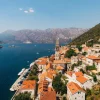 Historic town of Perast along the Bay of Kotor, with its iconic bell tower and two islands in the background.