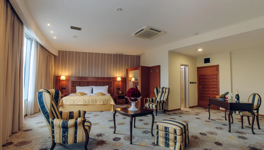 Luxurious hotel room in Podgorica with elegant sofas, champagne, and comfort at Kings Park Hotel.