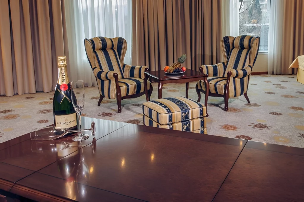 Kings Park Hotel luxury lounge with plush seating and champagne, inviting relaxation and comfort.