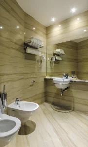 Elegant bathroom interior at Kings Park Hotel, a hotel in Podgorica with modern fixtures and marble walls.